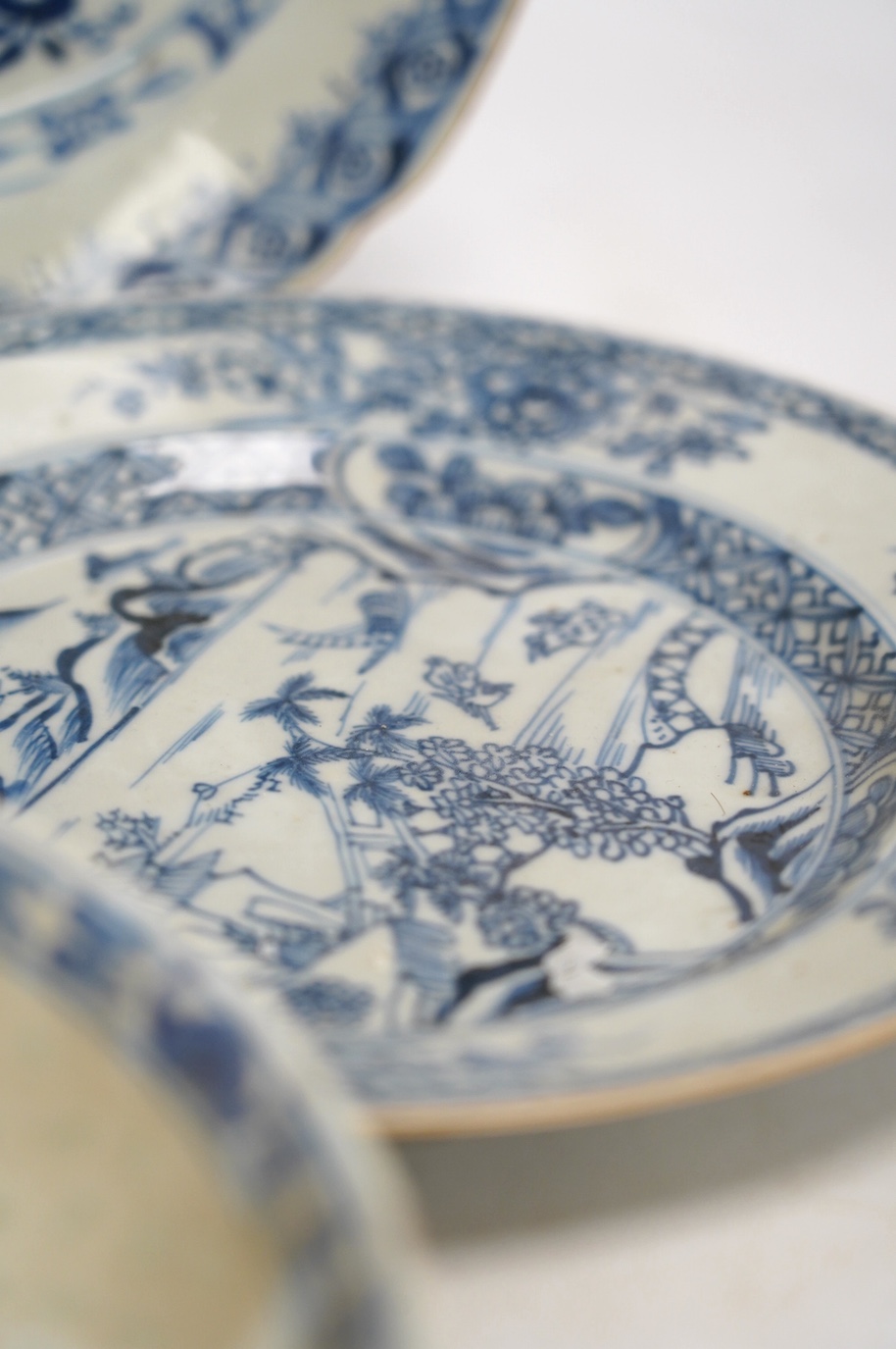 Four Chinese blue and white export plates and a rice bowl, bowl 24.5cm diameter. Condition - poor to fair, some damage to the edges